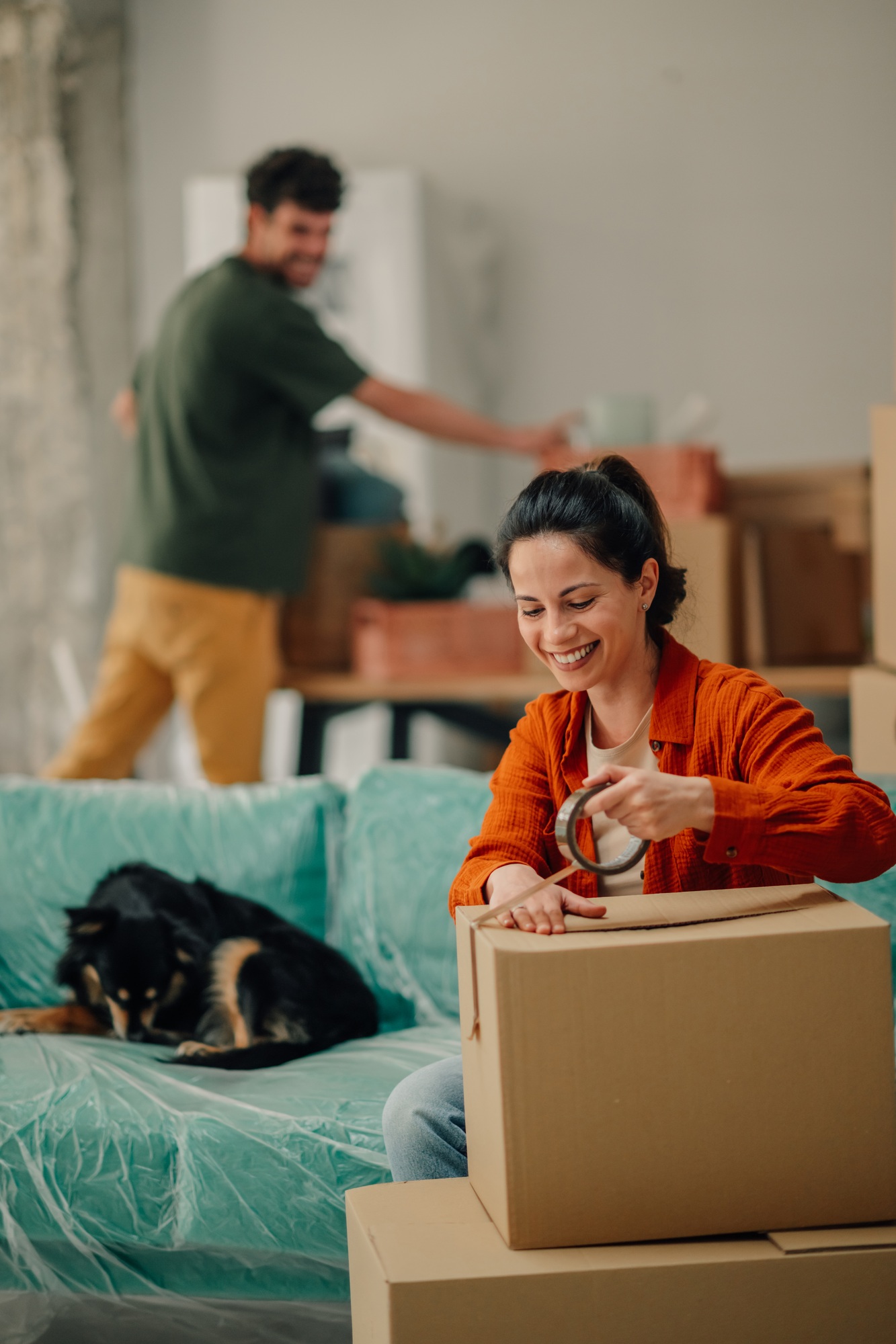 Couple packing boxes and moving into new home
