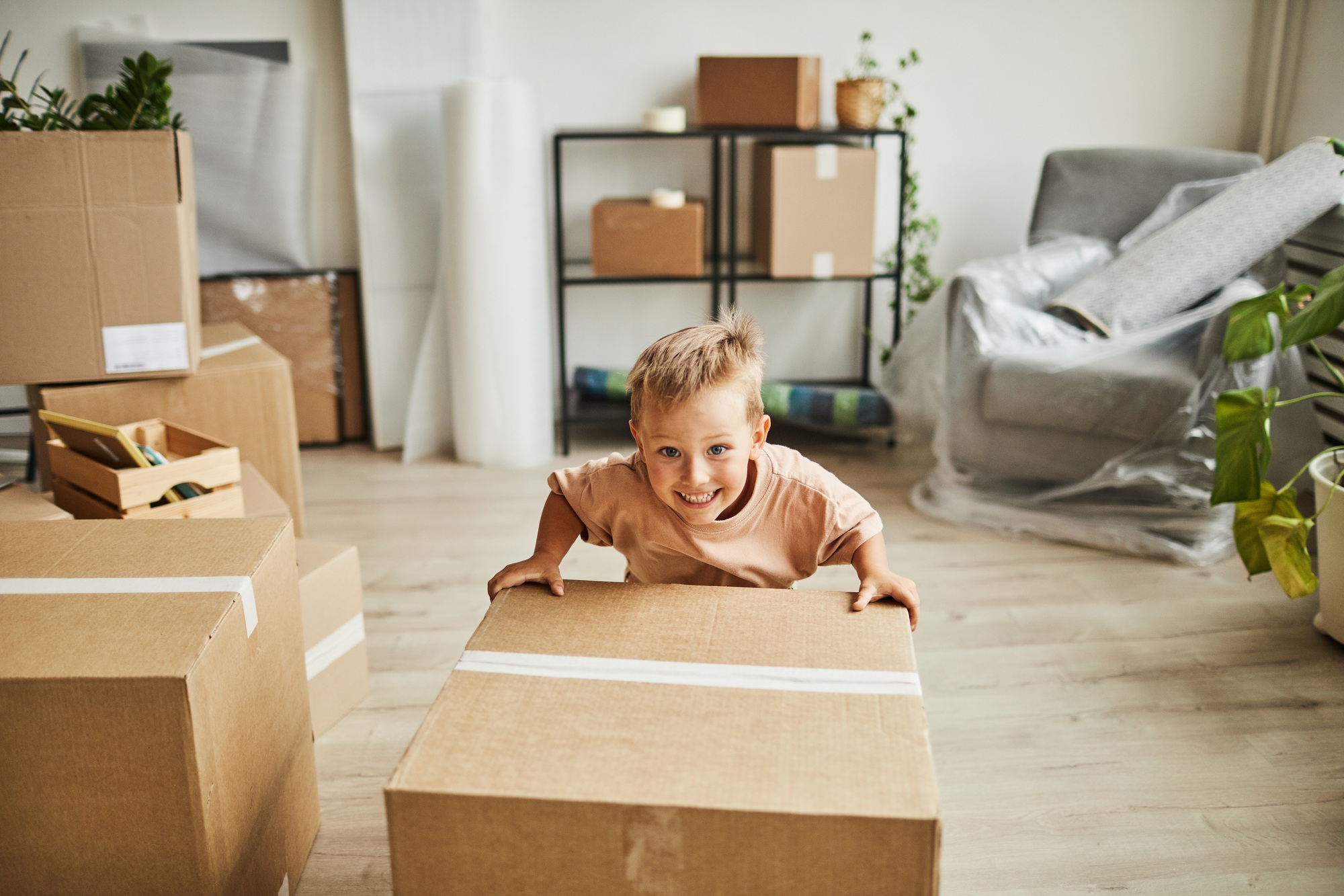 Smiling Boy Moving Boxes in New Home